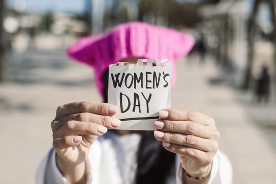 woman with a pink hat and the text womens day