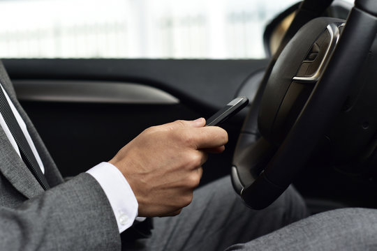 businessman using a smartphone in a car