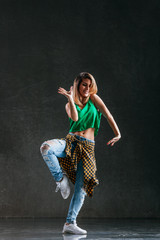 Young beautiful female dancer is posing in the studio