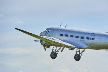 Fototapeta na wymiar Landing old propeller aircraft with extended landing gear 