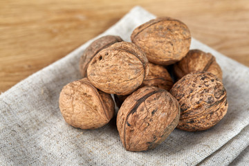 A stack of walnuts piled together and on rustic wooden background, shallow depth of field, selective focus