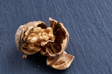 Top view close-up shot of cracked walnuts on dark background, shallow depth of field, macro
