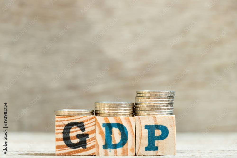 Sticker Block in word GDP (Gross domestic product) with coin in increase trend on wood background