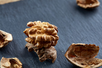 Top view close-up shot of cracked walnuts on dark background, shallow depth of field, macro
