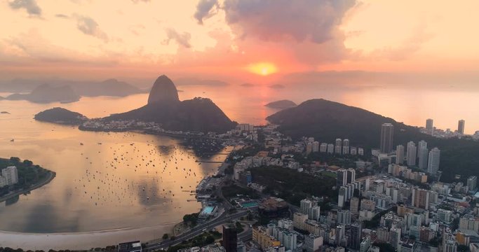 Aerial above Botafogo Bay at sunrise, Rio de Janeiro, Brazil. Orange sun above the ocean