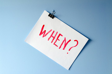 The word When? painted on white paper sheet asking for help in solving a mystery and finding a...
