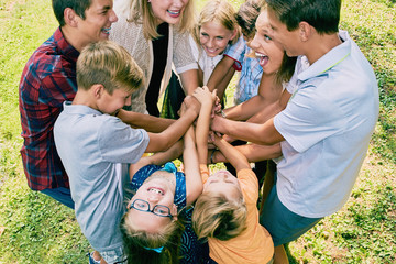 Excited children team heaping hands in summer