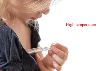 The little girl measures the temperature. mercury thermometer. Close Up. Looks at the thermometer...