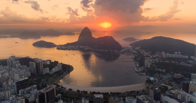 Aerial view of Sugarloaf Mountain and Botafogo Bay at sunrise in Rio de Janeiro, Brazil. Reflection of the rising sun on water