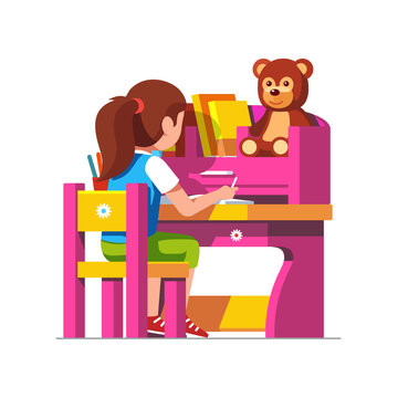 School girl studying sitting at pink child desk