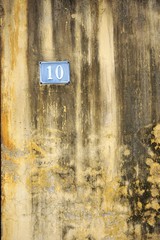 Number 10 address sign on weathered wall in Vietnam