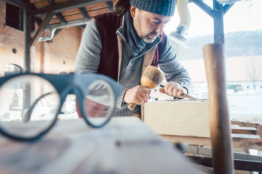Stonemason with protective glasses in his workshop