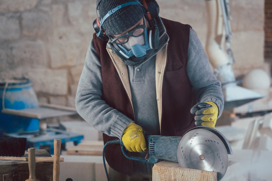 Stonemason cutting stone with saw in workshop
