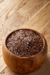 Wooden spoon with flax seeds on rustic background, top view, close-up, shallow depth of field, selective focus