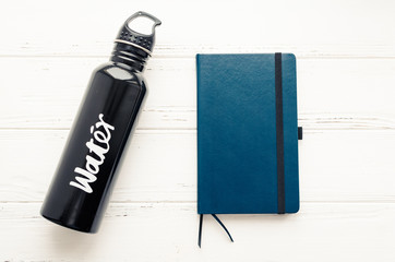 Black aluminum reusable water bottle and notebook