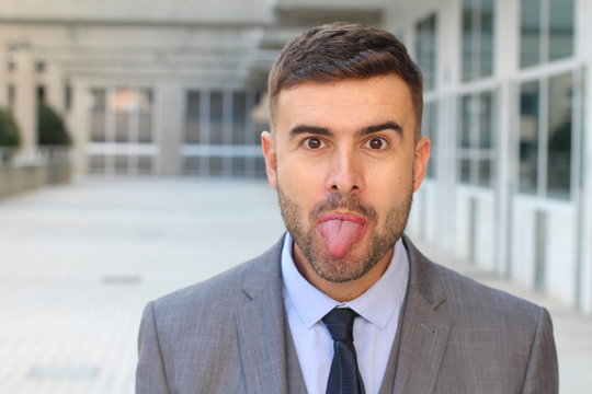 Playful businessman sticking his tongue out 