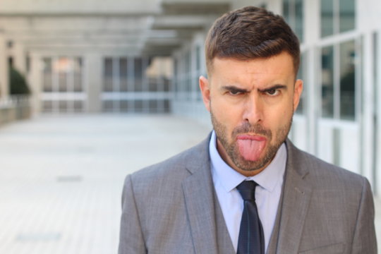 Businessman sticking his tongue out