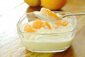 yogurt topping orange scooping on spoon in glass cup