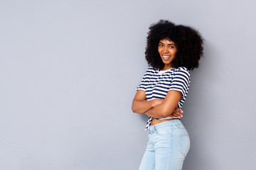 attractive black woman smiling with arms crossed against white background