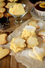 Obraz na płótnie Canvas Shaped shortbread cookies covered with sugar powder surrounded by kitchen utensils