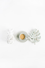 Decorations: pineapple, coffee, monstera palm leaf on white background. Flat lay, top view blog hero header.