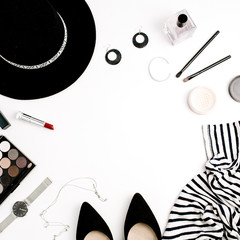 Woman fashion flatlay. Frame of modern clothes, accessories and cosmetics. T-shirt, hat, shoes, palette, lipstick, watches, powder on white background. Flat lay, top view.