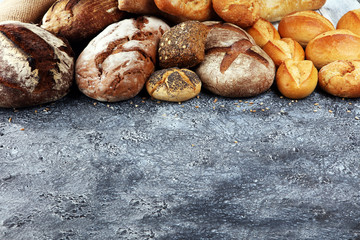 Different kinds of bread and bread rolls on board from above. Kitchen or bakery poster design
