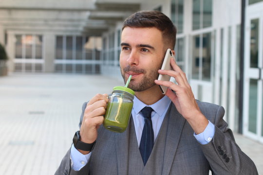 Healthy businessman drinking juice while working 