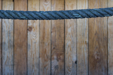blaues Seil als Handlauf im oberen Drittel Bretterwand im Hintergrund mit selektiver Schärfe