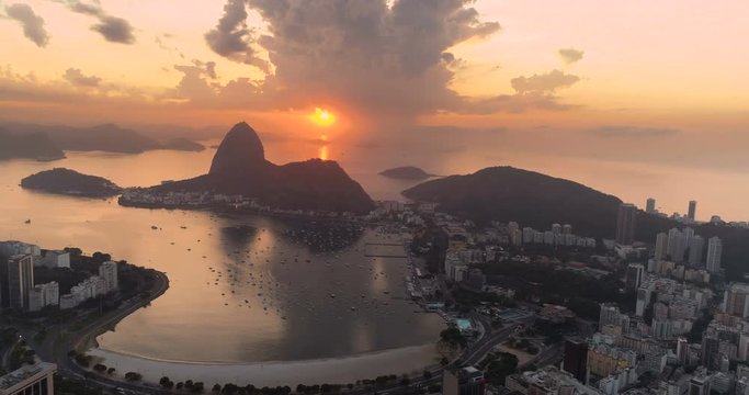 Flying above buildings in Botafogo Bay and Sugarloaf Mountain at sunrise. Rio de Janeiro, Brazil