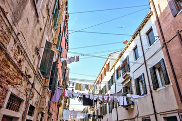 Fototapeta na wymiar Daylight wide view from bottom to clothes line of laundry drying outdoors