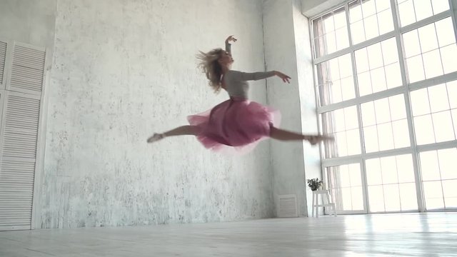 young girl dancer jumping high. graceful girl practicing ballet in the studio. beautiful ballet dancer performs a jump, and classical ballet