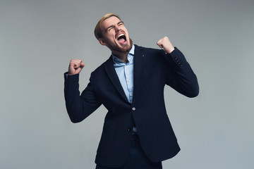 Professional and happy. A portrait of a business person enjoying the success in front of the grey background.
