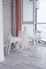 The perfect place for a romantic dinner. A table for two in white colors. The restaurant with a gorgeous view from the panoramic Windows. 