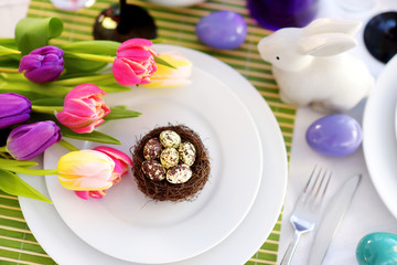 Beautiful table setting with crockery and flowers for Easter celebration