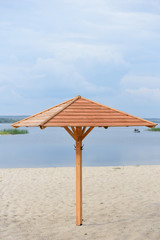 Wooden umbrella on the beach for clothes. Sun protection