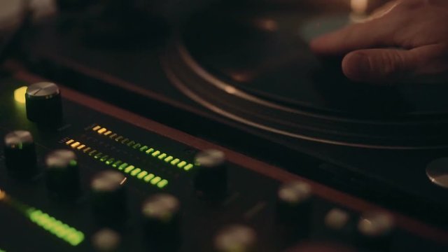 Music dj or vj at cool trendy party in bar or night club, scratches vinyl to produce unique sound, moves controllers and buttons. Professional night lifestyle technology