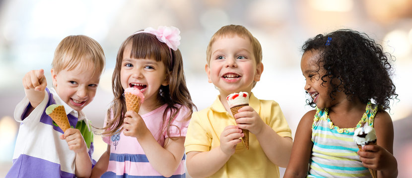 happy kids group eating ice cream at a party in cafe