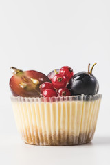 close up view of sweet cupcake with cream and tangerine isolated on white