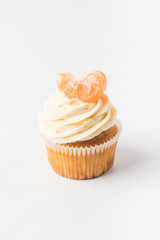 close up view of sweet cupcake with berries, fruits and tangerine near by isolated on white