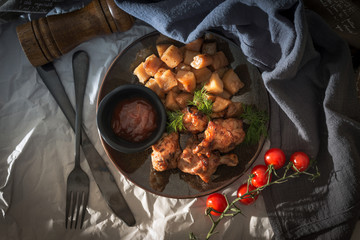 Chicken wings with sauce and golden French fries potatoes