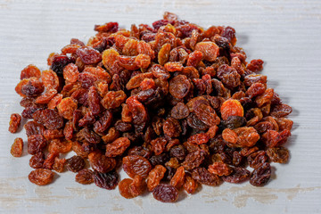 pile of organic raisins on white wooden table