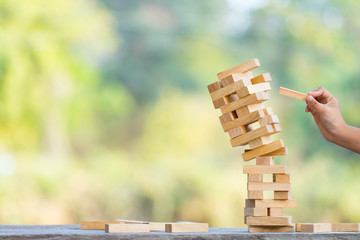 The jenga game ,tower stack from wooden blocks toy and  hand take on block