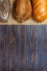 Assortment of baked bread on wooden table background. top view with copy space