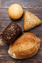 Bakery background, bread assortment on black wooden backdrop. Top view with copy space