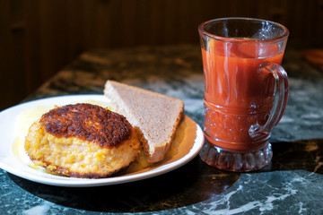 Fototapeta na wymiar cutlet and mashed potatoes and bread on a plate and a glass of tomato juice