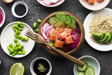 Fresh seafood recipe. Shrimp salmon poke bowl with fresh prawn, brown rice, cucumber, pickled sweet onion, radish, soy beans edamame portioned with black and white sesame. Food concept poke bowl