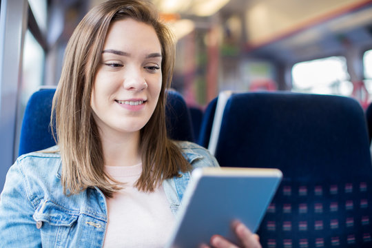 Young Woman Using Digital Tablet During Train Journey