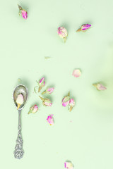 Obraz na płótnie Canvas Table decoration with antique teaspoon and dried roses, tea party concept