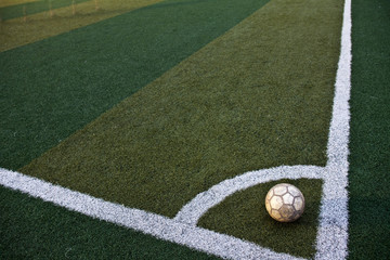 Old leather soccer ball on a green lawn